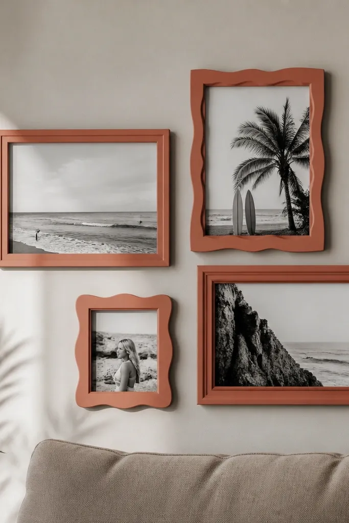 A cluster of three to four mismatched frames spray-painted matte in the same warm color, arranged on a wall with consistent spacing. Black-and-white photos sit inside.