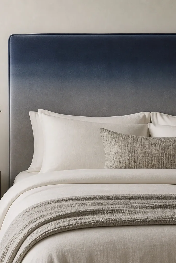 A headboard with a gentle vertical ombre from deep navy at the top to softer gray at the bottom; thin piping runs around the perimeter.